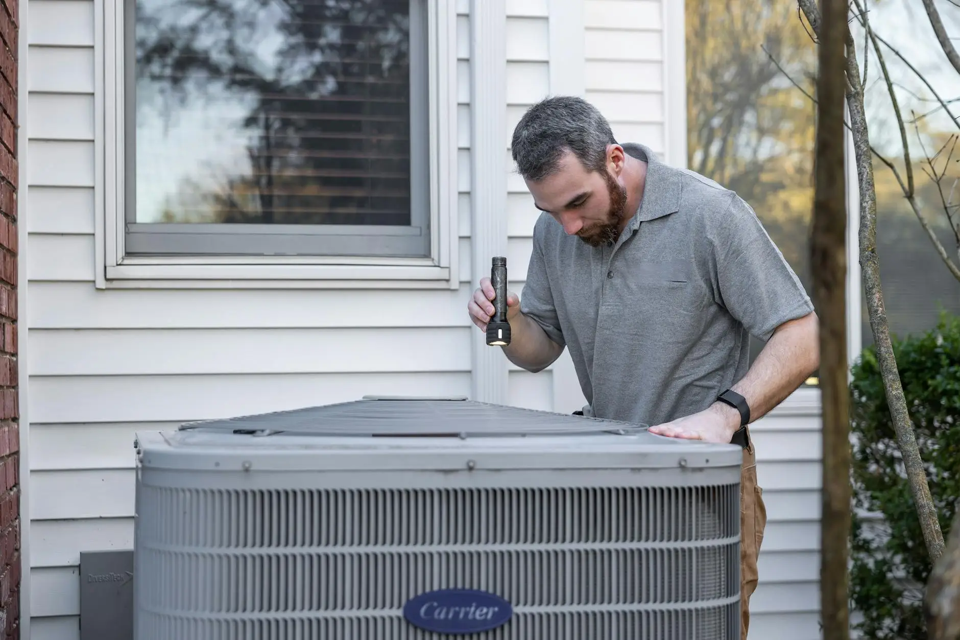 A professional roofing inspector examining shingles and flashing on a residential roof in Simpsonville.